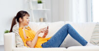 Young woman sitting on a couch with earbuds