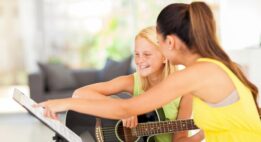 College Student Teaching Guitar Lessons to younger girl